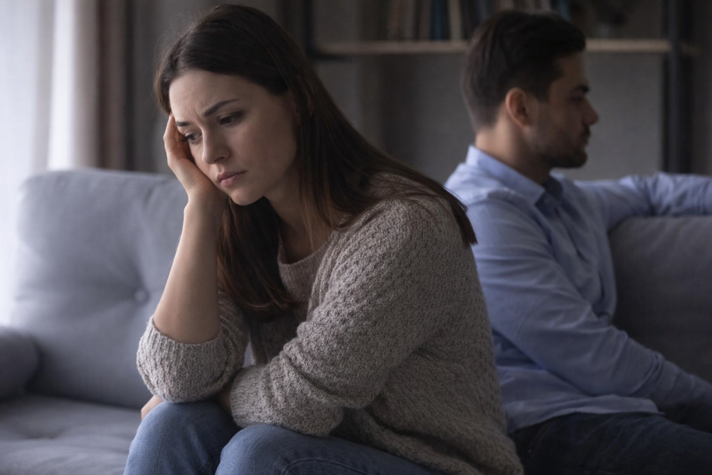 femme triste se sent seule dans son couple assise à côté de son partenaire distant